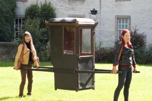 Professor Alice Roberts and a colleague carry a chair in Edinburgh for the programme